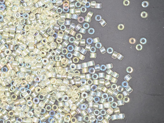 a collection of small, clear beads scattered on a dark surface.