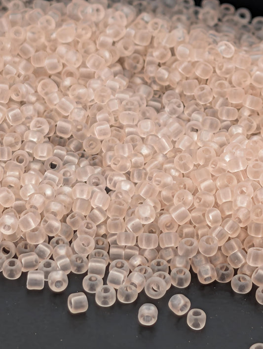 a pile of clear, transparent beads scattered on a dark surface.