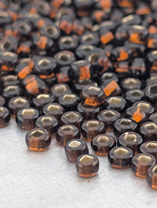 a large number of small, round, brown glass beads scattered across a surface.