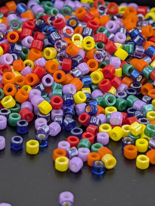 A colorful pile of multicolored plastic beads scattered on a dark surface.
