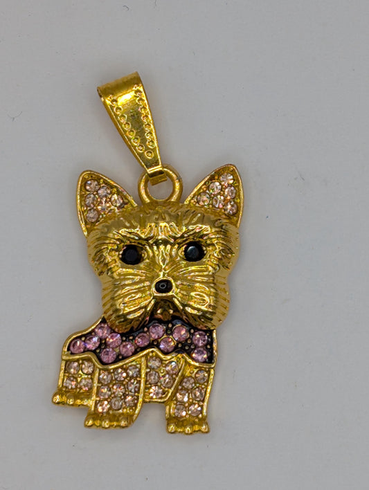 A gold-colored pendant in the shape of a dog, adorned with small diamonds or gemstones.