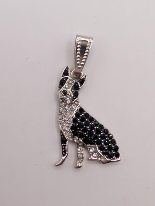 A silver-toned pendant in the shape of a dog, adorned with black and white diamonds.