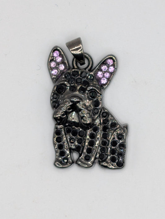 A pendant in the shape of a dog&#39;s head, with a metallic appearance and small purple gemstones or stones embedded in it.