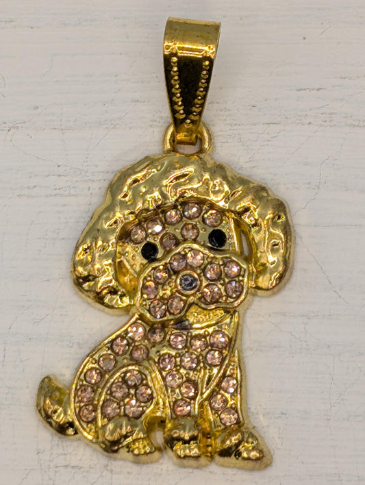 A gold-colored pendant in the shape of a dog, adorned with small diamonds or gemstones.