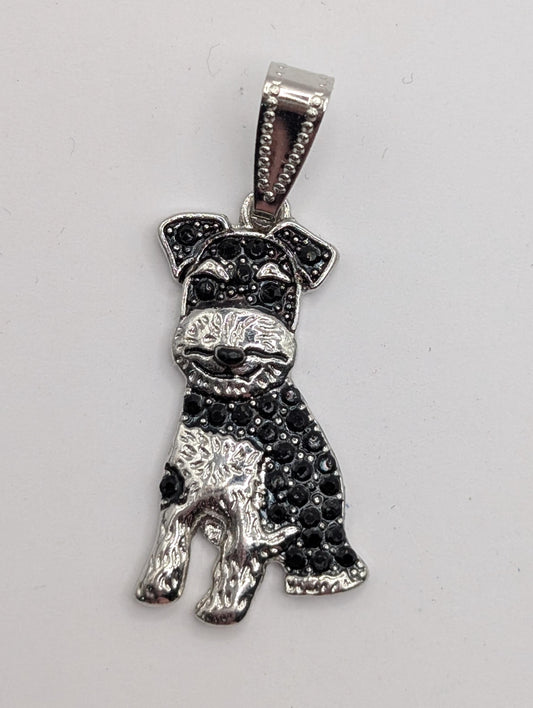 A silver-colored pendant in the shape of a dog, with black rhinestones or crystals adorning it.