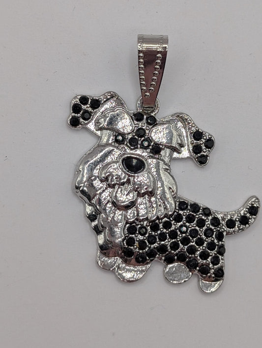 A silver-colored pendant in the shape of a dog, adorned with black rhinestones.