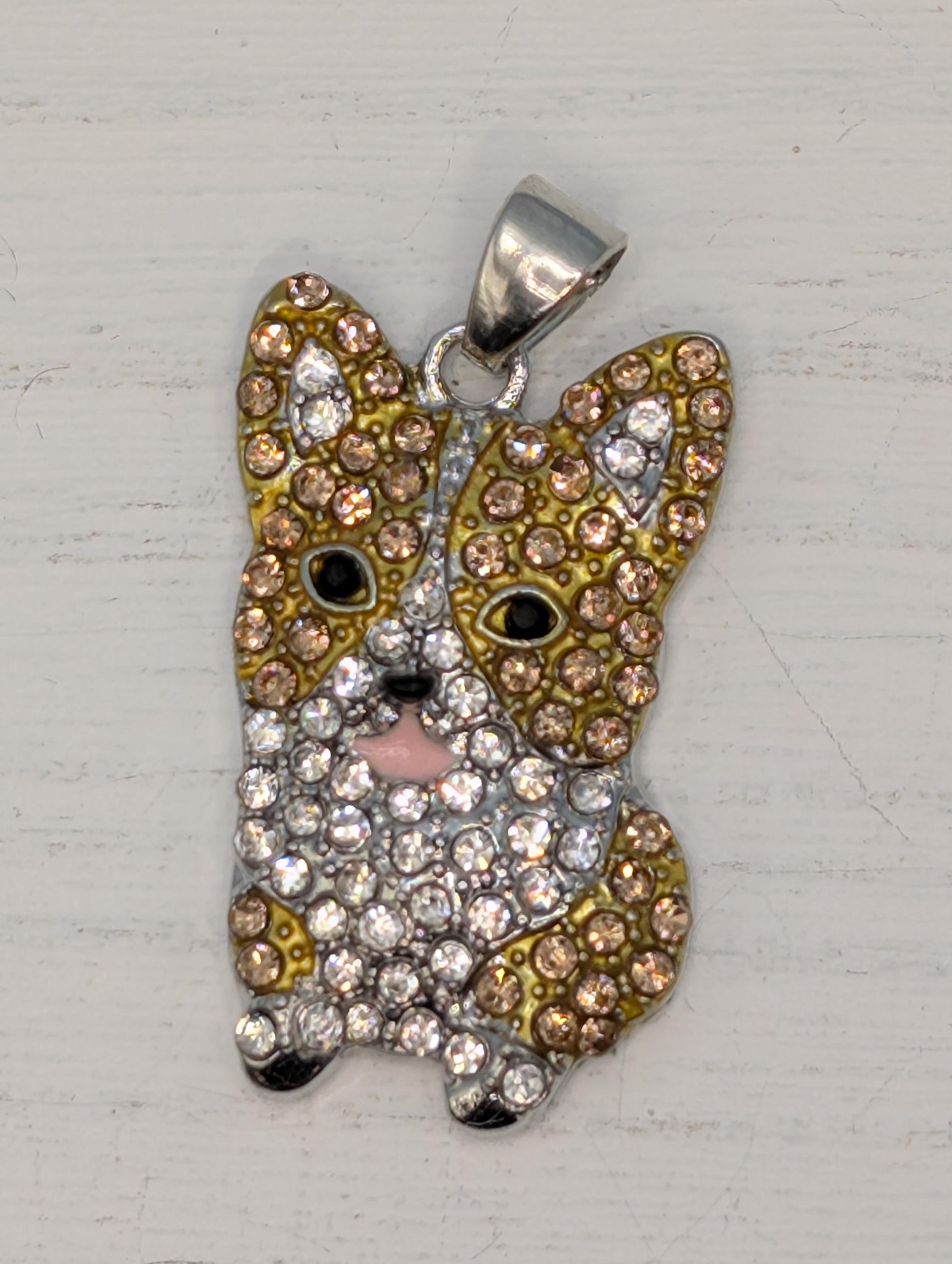 A pendant in the shape of a dog, adorned with numerous sparkling rhinestones in various colors.