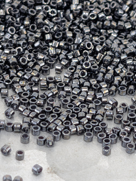a large pile of small, shiny metal beads or nuts scattered across a surface.